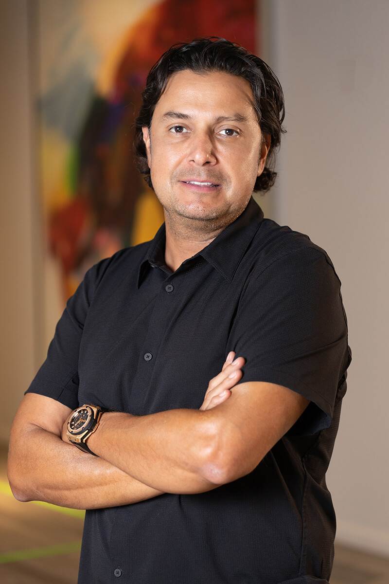 Professional portrait of Alejandro Orozco from Triple A Restaurant Group, wearing a black button-up shirt and confidently posing with arms crossed — representing leadership, innovation, and strength in hospitality management.