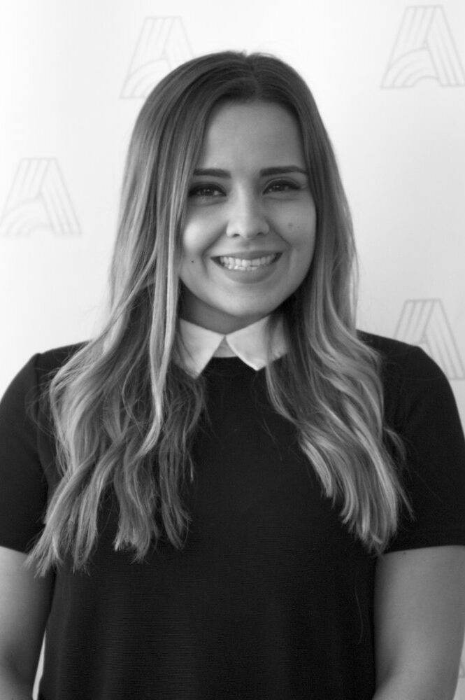 Portrait of Alejandra Ibarra, a valued team member of Triple A Group, smiling confidently in a black-and-white photo—reflecting professionalism, approachability, and pride in her role.