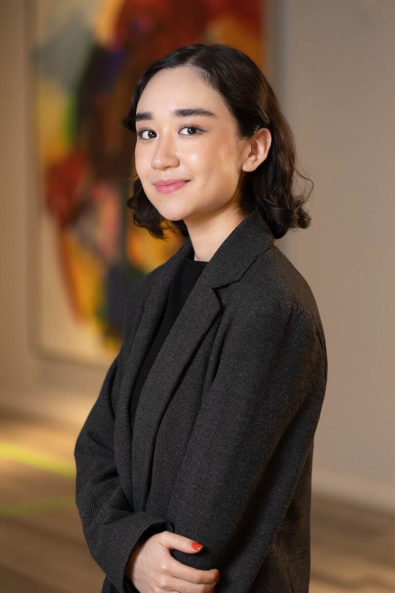Professional portrait of Annette Escárcega from Triple A Restaurant Group, wearing a dark blazer and smiling confidently in a modern office — representing creativity, professionalism, and hospitality leadership.