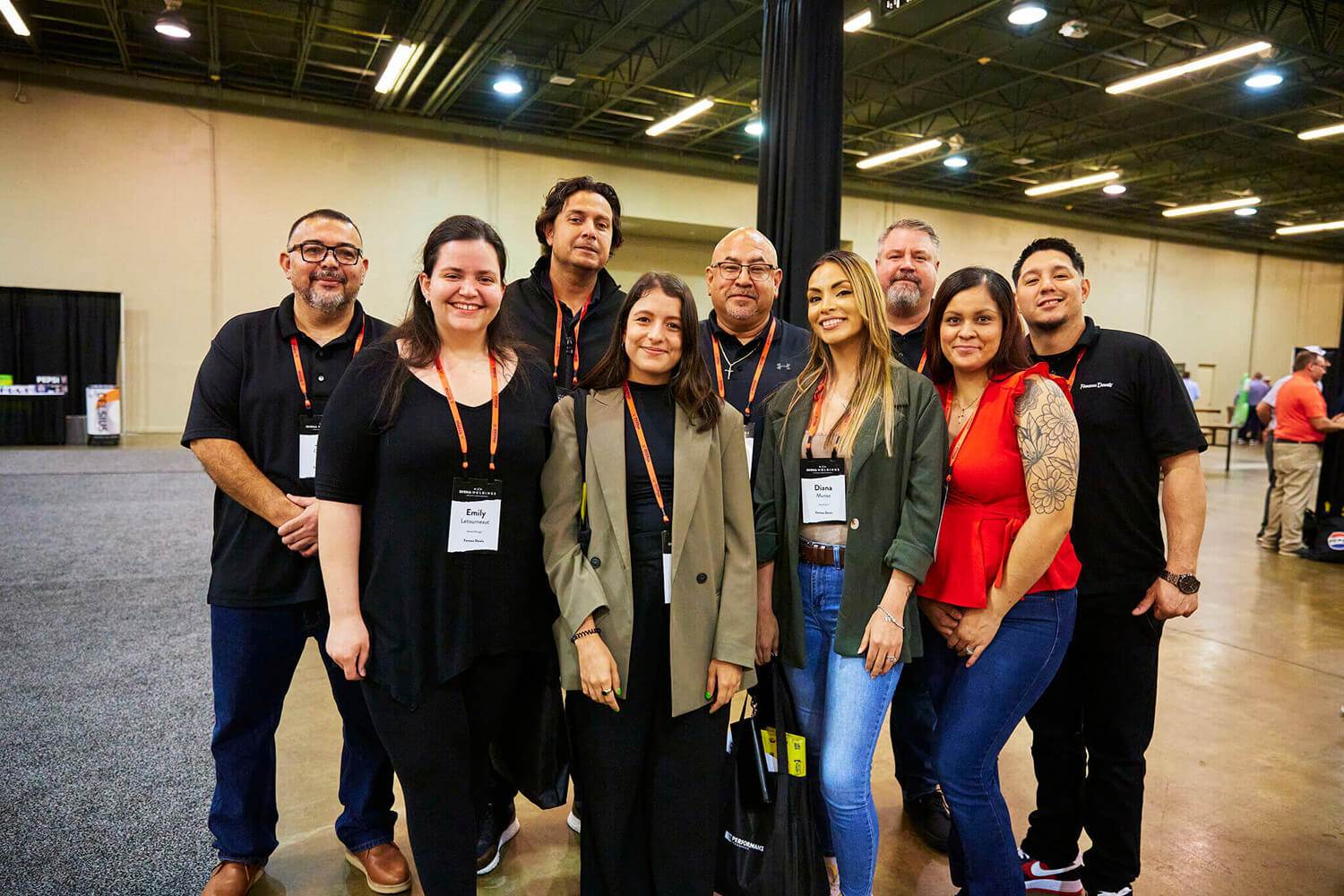 A team from Triple A poses together at the 2024 BBQ Holdings Conference in Dallas, Texas. The group stands inside the event venue wearing name badges and lanyards, representing their company with pride and professionalism.